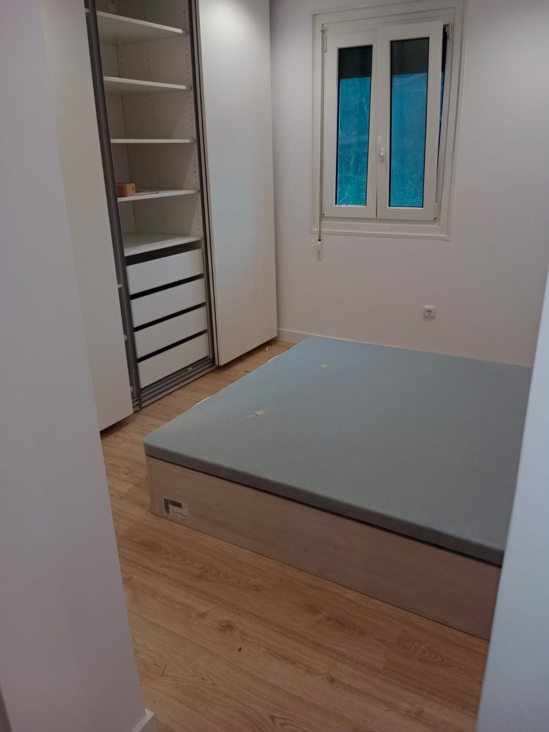 Dormitorio con armario y suelo laminado